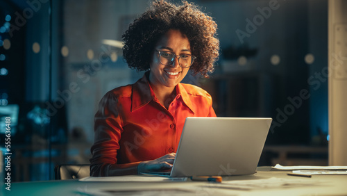 Cuadro en lienzo Young Black Female Working on Laptop Computer in Creative Office in the Evening