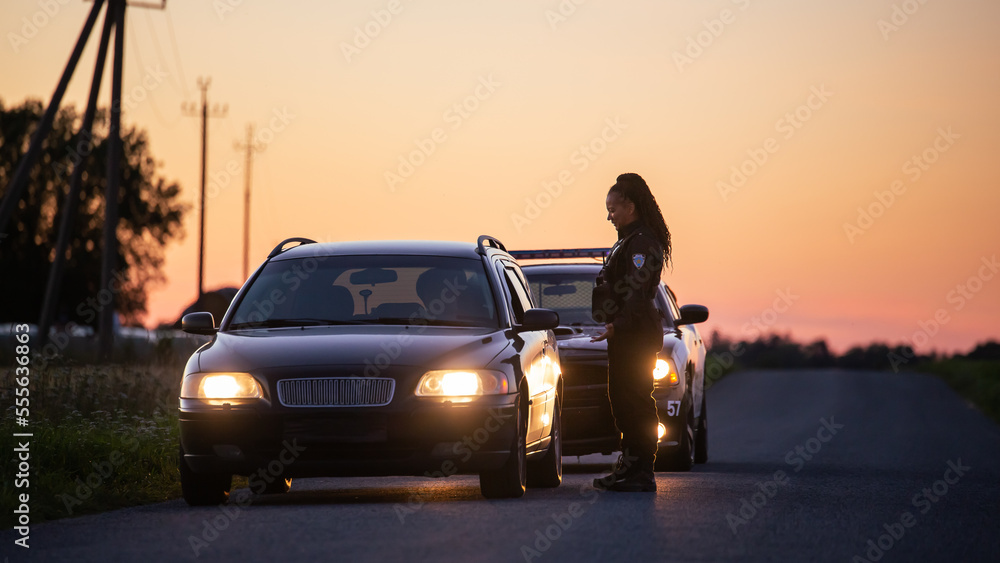Fototapeta premium Highway Traffic Patrol Car Pull over, routine Check, Road Inspection Stop. Friendly Black Female Police Officer Smiling, Approaches Vehicle, Asks Driver License and Registration.