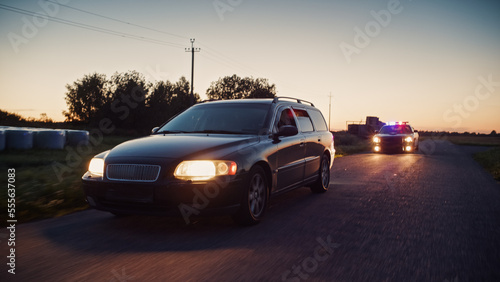 Traffic Patrol Car in Pursuit. Police Officers in Squad Car Chasing Suspect on Industrial Road, Sirens Blazing, High Speed. Cops on Emergency Response Call. Stylish Cinematic High Speed Action Scene © Gorodenkoff
