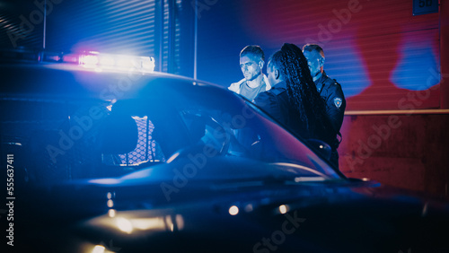 Two Police Officers Arrest Suspect, Put Him in Patrol Сar. Officers of Law Handcuff Dangerous Criminal on City Street. Officers of the Law and Under Arrest Felon, Fight Crime. Cinematic