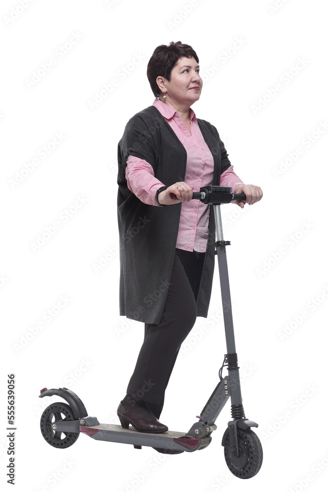 in full growth. confident mature woman with an electric scooter in full growth. confident mature woman with an electric scooter