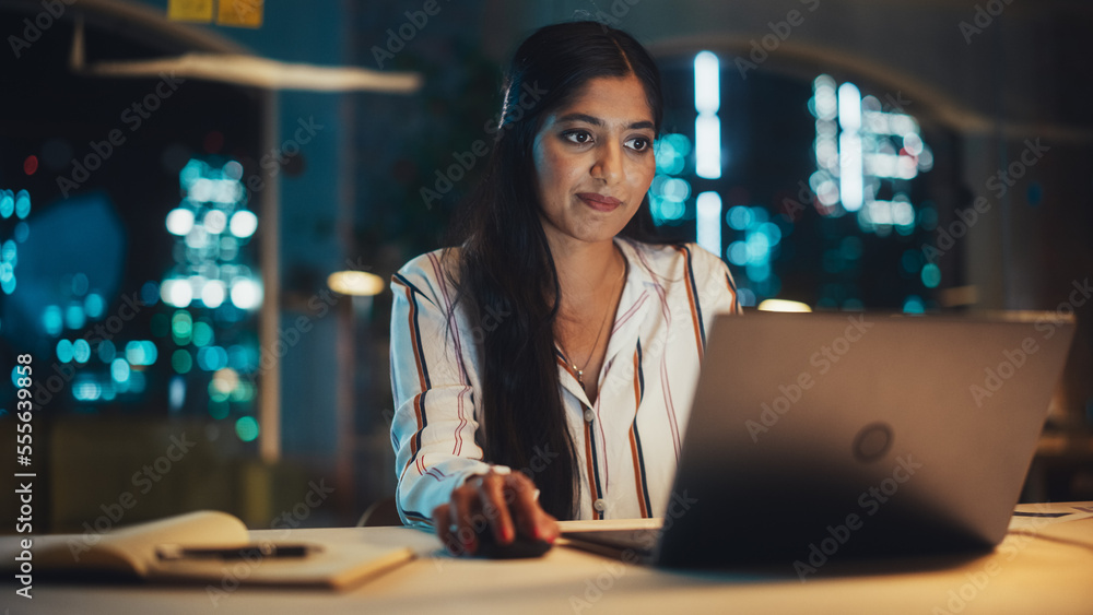 Indian Female Working in Creative Agency in the Evening, Implementing Modern Business Strategy for Clients. Successful Specialist Using Laptop Computer for Serious Work. Indian Female Working in Creative Agency in the Evening, Implementing Modern Business Strategy for Clients. Successful Specialist Using Laptop Computer for Serious Work.