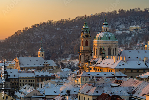 Mala Strana and St. Nicholas Church in old town of Prague covered in snow in the winter morning.