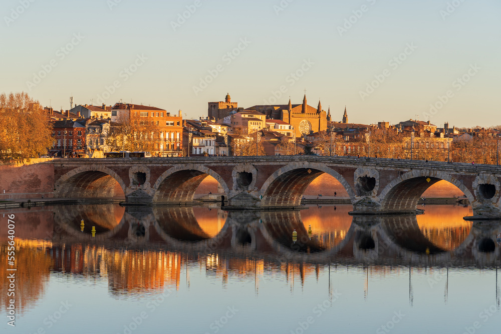 Scenic autumn sunset view of the Pont Neuf or New Bridge on the Garonne river in the famous pink city of Toulouse, France