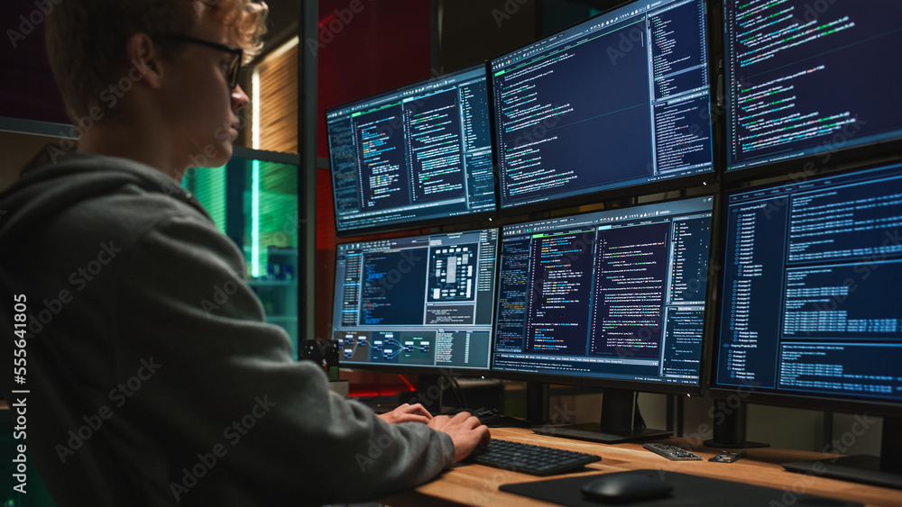 Young Caucasian Man Writing Code on Professional Six Monitors Setup in Dark Office. Male Cyber Security Specialist Controlling Digital Data Protection System For International SAAS Firm