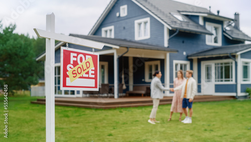 Bild auf Leinwand Young Couple Visiting a Potential New Home Property , SHaking Hands with Professional Real Estate Agent