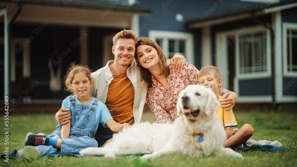 Portrait of a Cheerful Family Couple with a Son and Daughter, and a Beautiful Golden Retriever Dog Sitting on a Lawn in Their Front Yard at Home. Happy People Looking at Camera and Smiling. Portrait of a Cheerful Family Couple with a Son and Daughter, and a Beautiful Golden Retriever Dog Sitting on a Lawn in Their Front Yard at Home. Happy People Looking at Camera and Smiling.