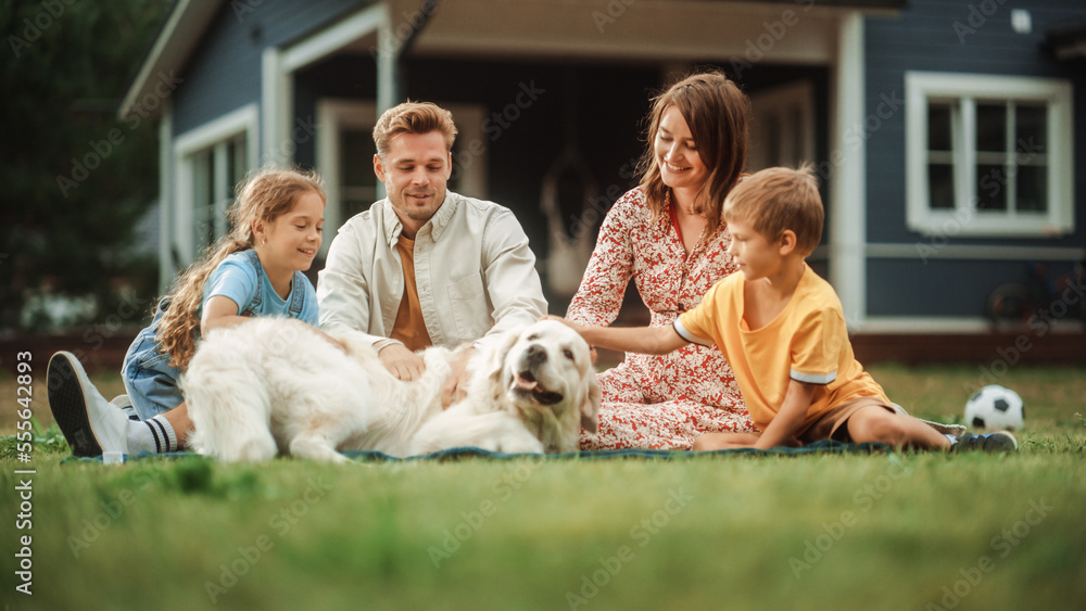 Portrait of a Happy Young Family Couple with a Son and Daughter, and a Noble White Golden Retriever Dog Sitting on a Grass in Their Front Yard at Home. Cheerful People Petting the Dog and Smiling. Portrait of a Happy Young Family Couple with a Son and Daughter, and a Noble White Golden Retriever Dog Sitting on a Grass in Their Front Yard at Home. Cheerful People Petting the Dog and Smiling.