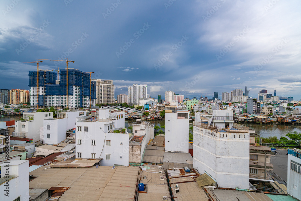 HO CHI MINH, VIETNAM - December 3, 2022: Slum wooden house on the Saigon river bank, in front of modern buildings in ho chi minh city. View to district 1, see Bitexco tower, Landmark 81. HO CHI MINH, VIETNAM - December 3, 2022: Slum wooden house on the Saigon river bank, in front of modern buildings in ho chi minh city. View to district 1, see Bitexco tower, Landmark 81.