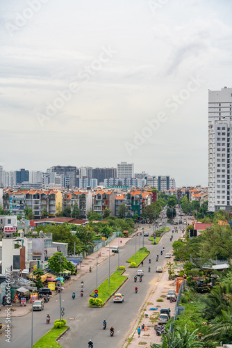 HO CHI MINH, VIETNAM - December 3, 2022: Slum wooden house on the Saigon river bank, in front of modern buildings in ho chi minh city. View to district 1, see Bitexco tower, Landmark 81.