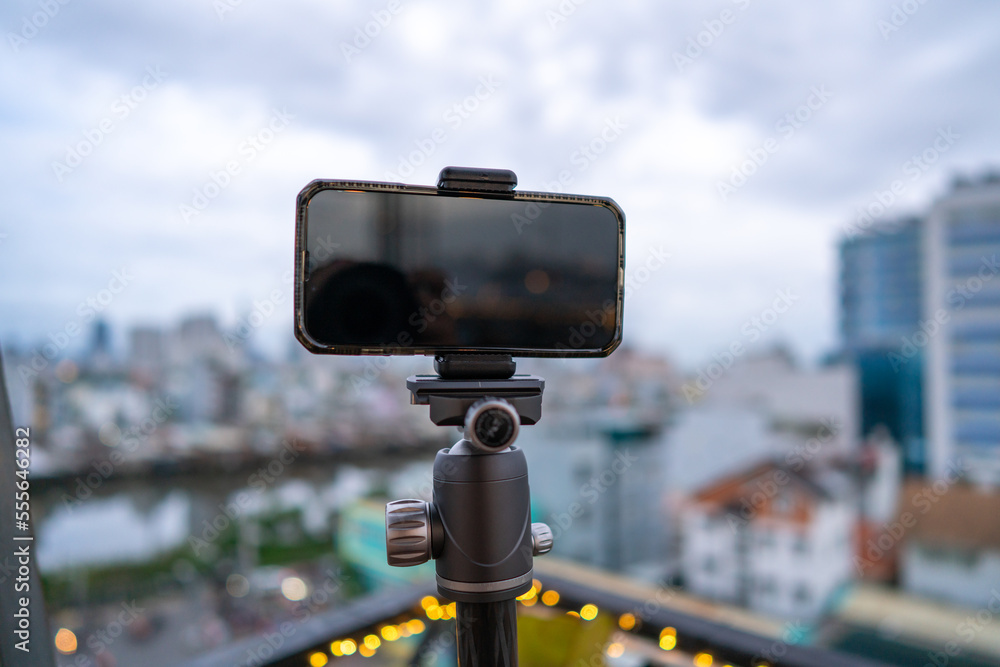 Close-up smartphone on tripod capturing night cityscape timelapse. Mobile photography or videography concept. Close-up smartphone on tripod capturing night cityscape timelapse. Mobile photography or videography concept.