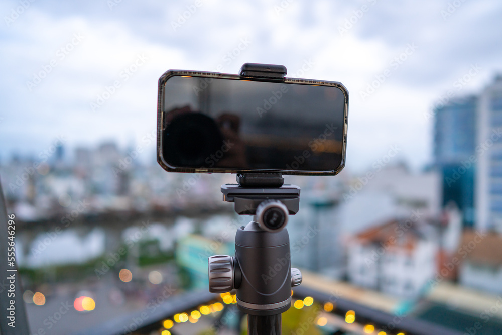 Close-up smartphone on tripod capturing night cityscape timelapse. Mobile photography or videography concept. Close-up smartphone on tripod capturing night cityscape timelapse. Mobile photography or videography concept.