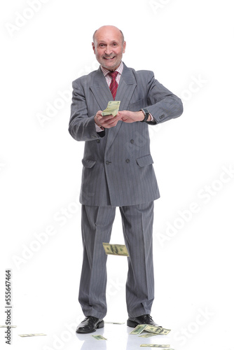 Mature businessman in suit and formal wear throwing in air dollar banknotes