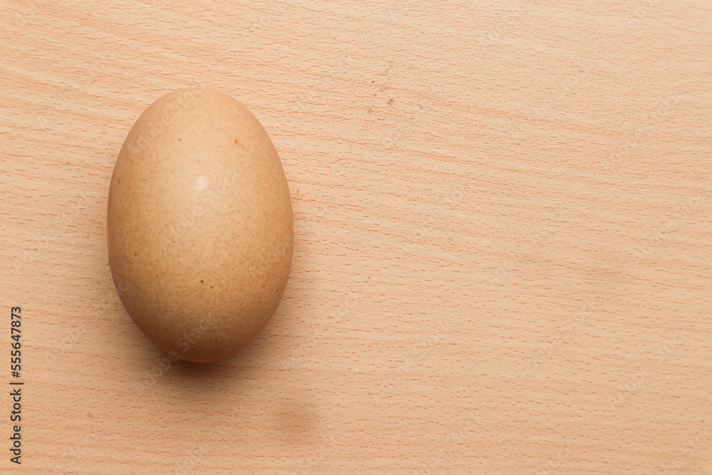 Chicken egg isolated on brown wooden background Chicken egg isolated on brown wooden background