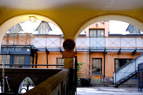 yellow courtyard arches with columns, historical high-rise building of 19th century with beautiful house vaults, street Helsinki city, tourist aspects of area Katajanokka, Helsinki, Finland