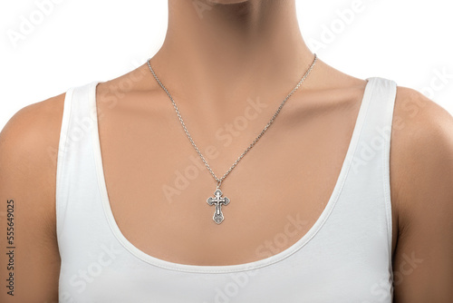 isolated on white background jewelry silver cross on a silver chain around the neck of a model girl. Front and side view of jewelry on girl