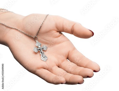 isolated on white background jewelry silver cross on a chain with a shadow lies on the hand of a girl model