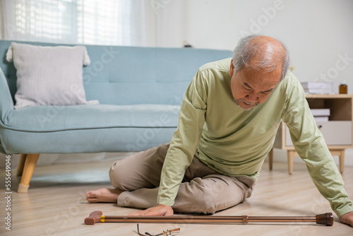 Older senior man headache lying on the floor after falling down he pain and hurt from osteoporosis, Elderly man falling on the floor alone with walking stick at home, Health care and medicine © sorapop