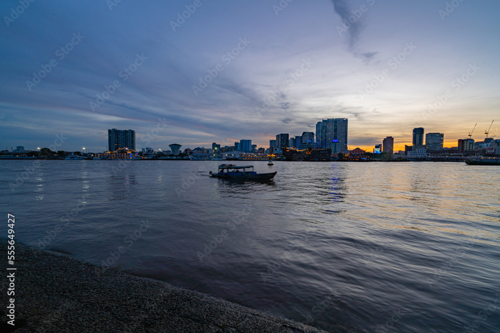 Ho Chi Minh City skyline and the Saigon River at sunset. Amazing colorful view of skyscraper and other modern buildings. Travel concept