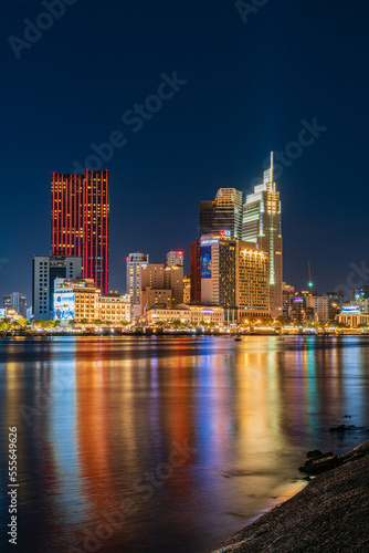 Ho Chi Minh City skyline and the Saigon River at night. Amazing colorful view of skyscraper and other modern buildings. Travel concept