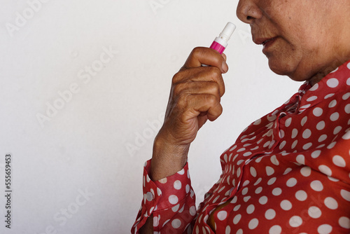 Closeup Asian woman use inhaler to smell for relieve dizzy or faint symptoms. Concept, health problem, sickness and remedy. Increases freshness, reduces dizziness and stuffy nose. self take care. 