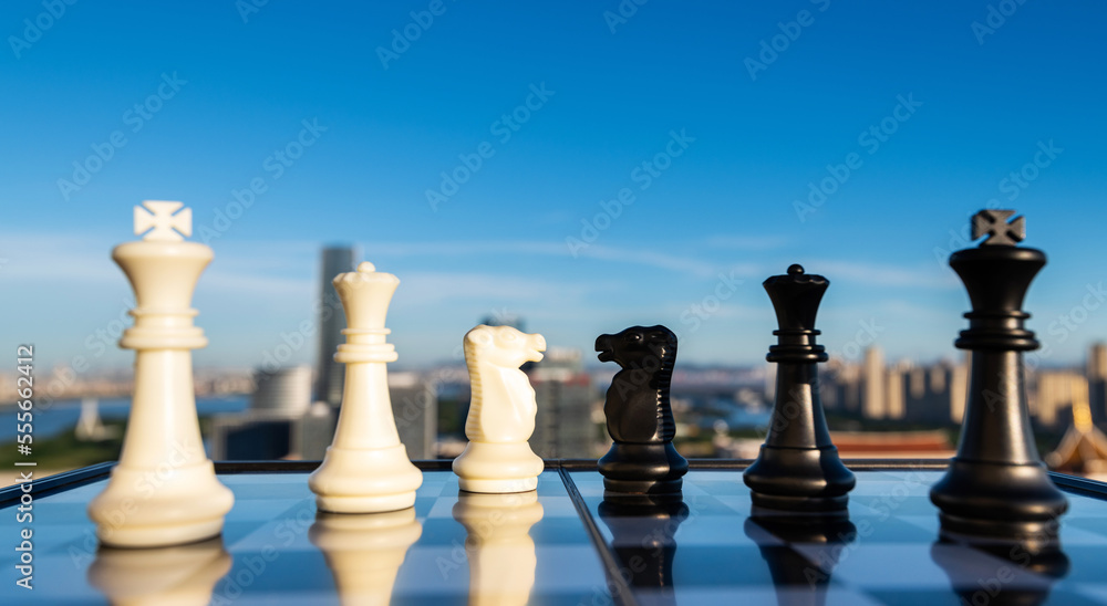 Black and white chess pieces on city background Black and white chess pieces on city background