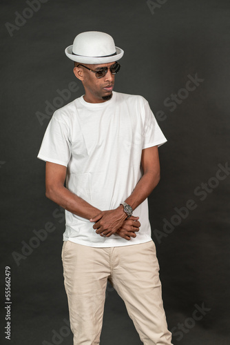 An african man wearing a white blank shirt doing a pose on the black background