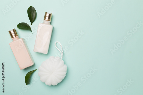 Shower gel with washcloth on color background, top view