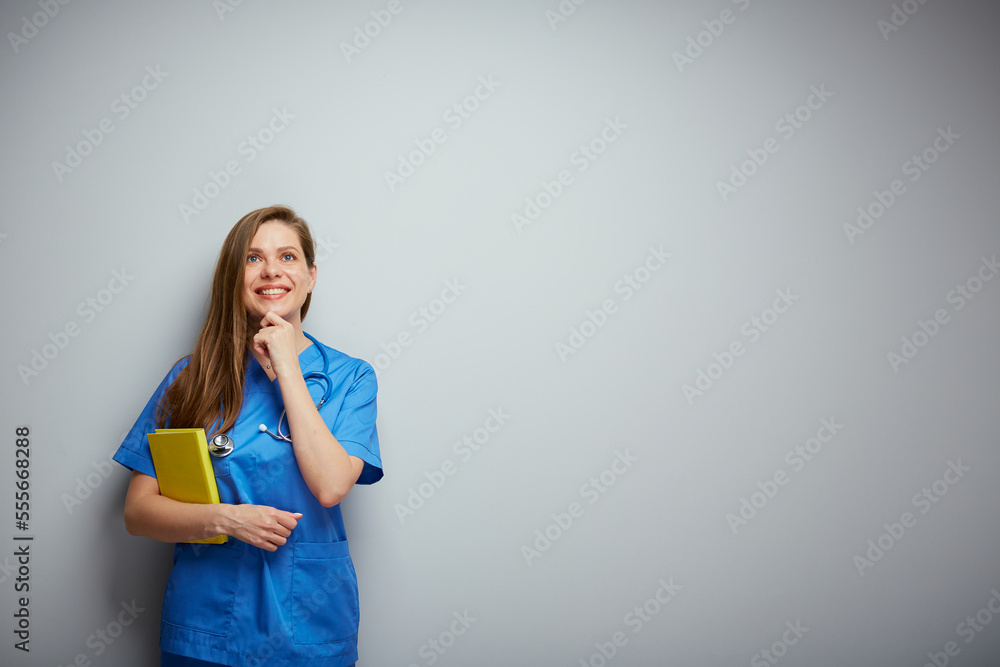 Woman medical student with book touching her chin and looking up. Woman medical student with book touching her chin and looking up.