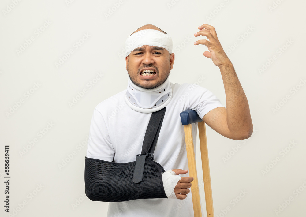 Depressed upset man suffering from pain. Broken arm. Asian man put on plaster bandage cast splint. Male patient wearing sling support arm after accident injury. life insurance and accident Depressed upset man suffering from pain. Broken arm. Asian man put on plaster bandage cast splint. Male patient wearing sling support arm after accident injury. life insurance and accident