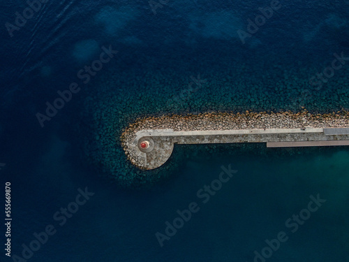 aerial view of a lighthouse in the entrance of a hourbor. Landmark of a port.