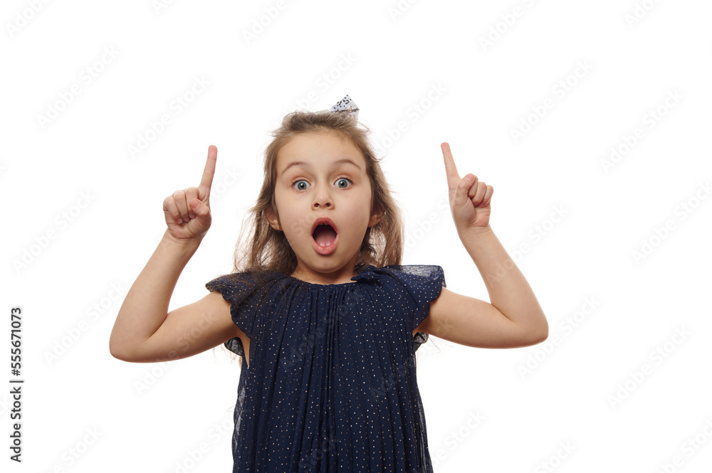 Isolated portrait on white background of a nice cheerful lovely cheery baby girl, in elegant navy dress, pointing forefinger up, finding solution, posing with open mouth and surprised look solution Isolated portrait on white background of a nice cheerful lovely cheery baby girl, in elegant navy dress, pointing forefinger up, finding solution, posing with open mouth and surprised look solution