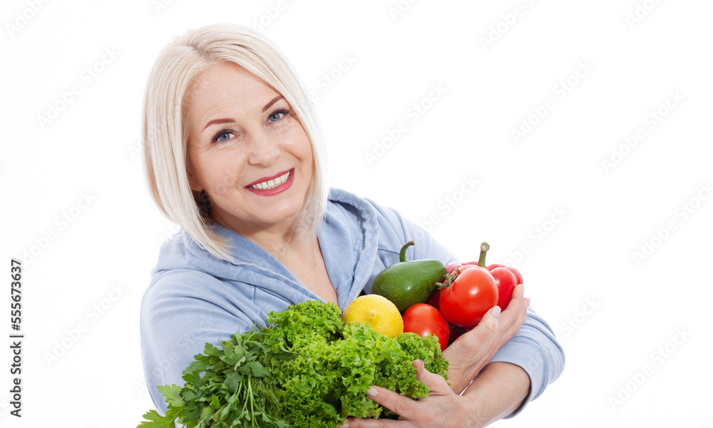 Happy woman with blond hair and beautiful smile holds a vegetables and herbs red pepper and green lettuce in her hands for a healthy diet. The concept of healthy eating vegetables.