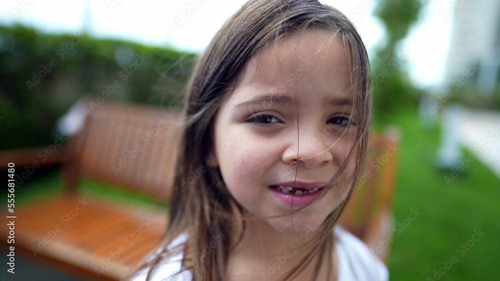 Portrait of little girl standing outside looking at camera child face closeup Portrait of little girl standing outside looking at camera child face closeup