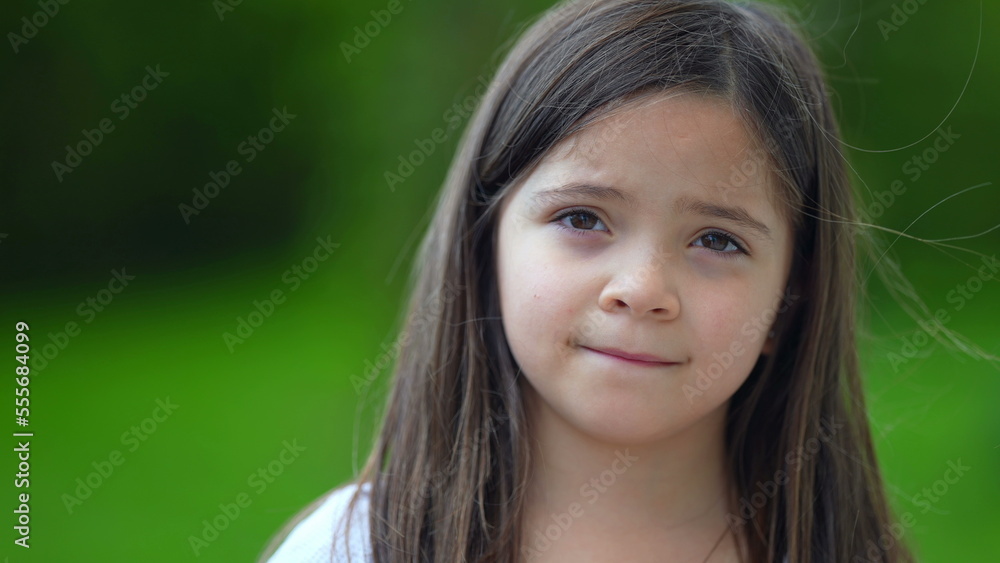 One adorable child face standing outside looking at camera small girl portrait One adorable child face standing outside looking at camera small girl portrait