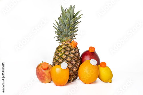 Fruits with a mouthpiece on a white background  to drink them as a juice bottle  pineapple  apple  persimon  orange  mango and lemon  close-up.