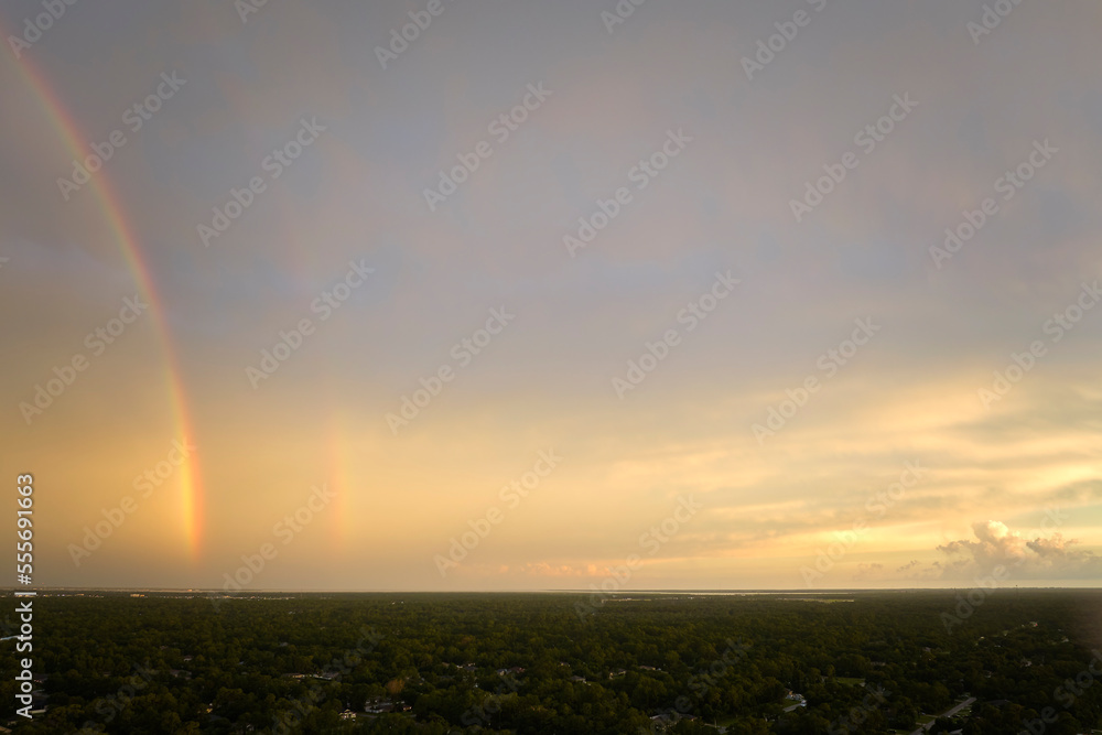 Colorful round rainbow against blue evening sky after heavy thunderstorm