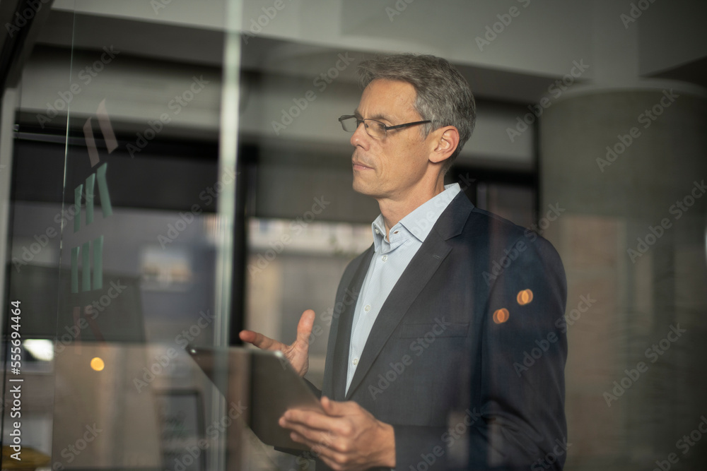 Portrait of successful businessman in office. Man writing on the glass board in office. Portrait of successful businessman in office. Man writing on the glass board in office.