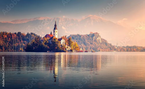 Scenic image of Fairytale lake Bled during pinc sunset. Natural summer scenery with colorful sky. Fantastic Picturesque Scene over famouse lake. Julian Alps. Slovenia. Wonderful Autumn landscape photo