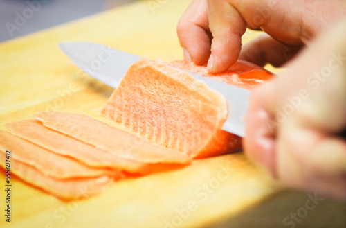 close up. professional chef slicing thin slices of salmon