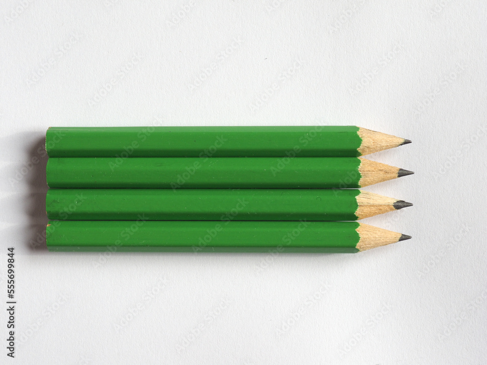 Obraz premium four green pencils on paper sheet