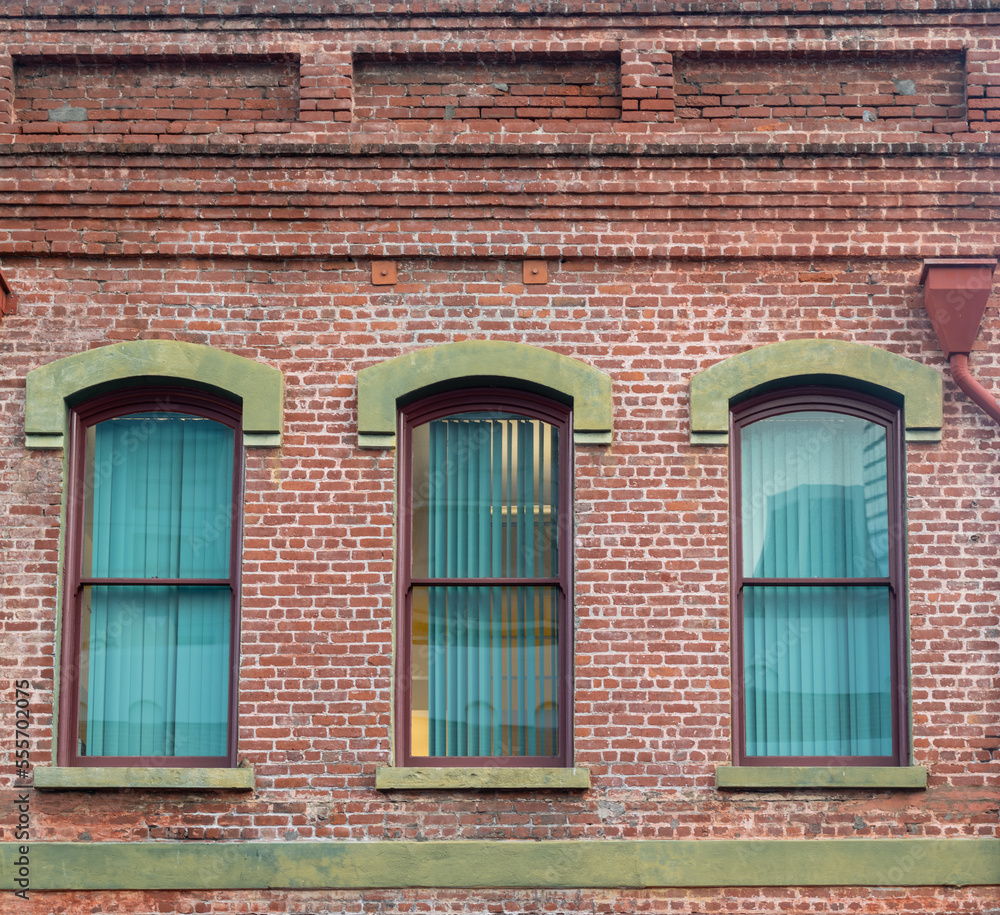Victorian Style Red Brick Building with Arched Windows and Green Facade