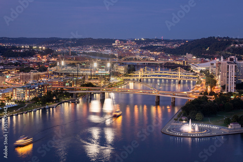 Cityscape of Pittsburgh and Evening Light. Fort Pitt Bridge. Blurry Ferry Cruise in Background Because of Long Exposure. Selective focus.