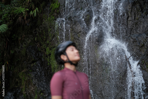 a young female cyclist practising breathing exercise by the waterfalls