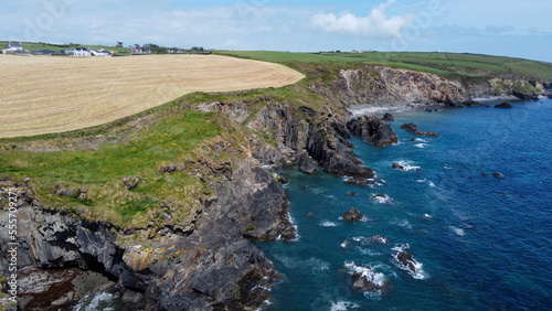 Farm fields on the shore of the Celtic Sea, south of Ireland, County Cork. Beautiful coastal area. Turquoise waters of the Atlantic. Picturesque stone hills. Aerial photo. View from above.