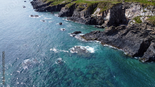 Seaside landscape of the south of Ireland. Picturesque coastal cliffs. The water of the Atlantic Ocean is turquoise. Drone point of view.