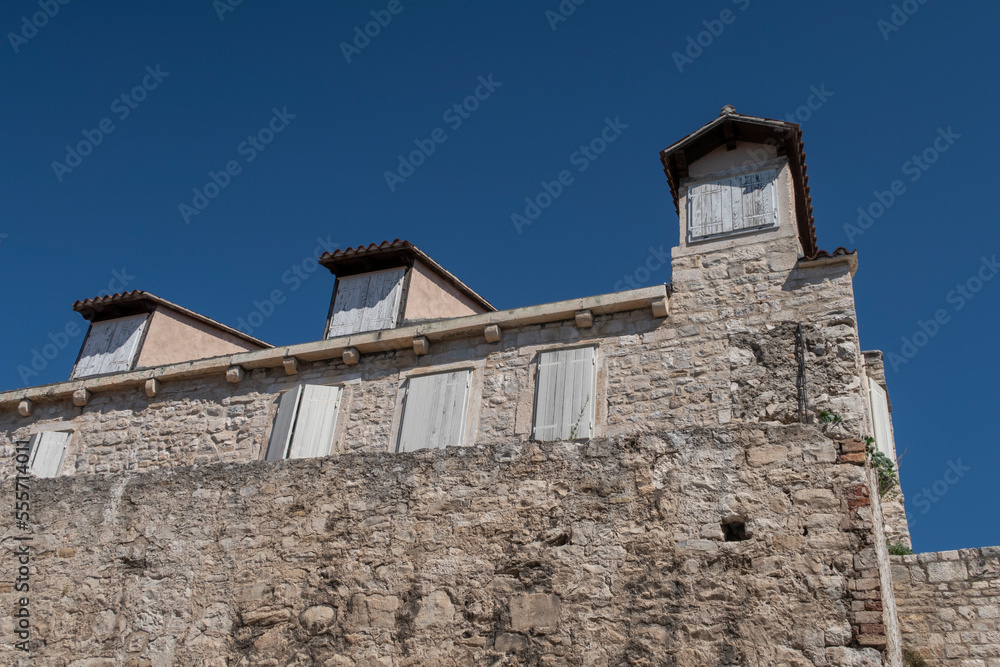 Old medieval wall with wooden window shutters in Split in Croatia