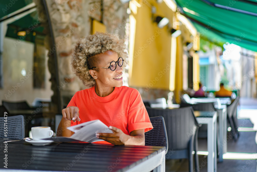 Portrait of woman with an afro hairstyle smiling in coffee shop cafe Portrait of woman with an afro hairstyle smiling in coffee shop cafe