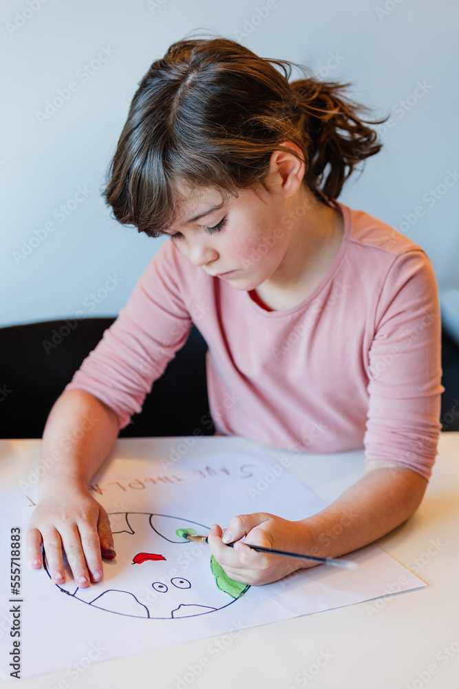Girl painting environmental banner on paper Girl painting environmental banner on paper
