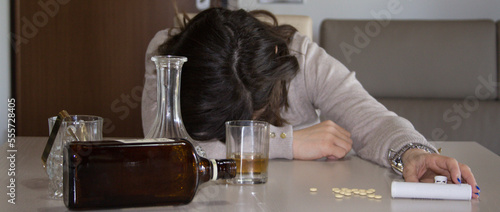 Image of a young woman passed out on the table after abusing alcohol and psychotropic drugs. Reference to the abuse and dependence of these substances. Horizontal banner 
 photo